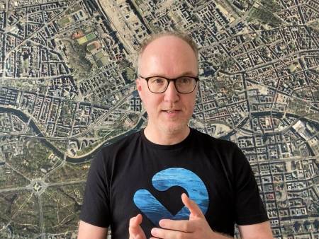 Illustration: Frage- und Ausrufezeichen, Megaphon sowie eine Gruppe Menschen mit Transparenten, grafisch-flächig dargestellt