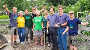 Eine sommerlich gekleidete Gruppe, manche von ihnen tragen ein Shirt mit «Freiblocks»-Aufdruck stehen Arm in Arm, lächeln und recken die Arme.