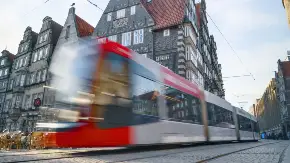 Eine Straßenbahn ist unscharf unterwegs in einer Stadt.