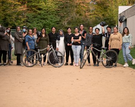 Eine ethnische gemischte Gruppe von Menschen auf einem Weg, vor ihnen zwei Fahrräder