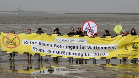 Eine Gruppe Menschen protestiert vor einem Gebäudeeingeng; sie halten ein Banner mit der Aufschrift  «Klimakrise stoppen – Gasimporte verhindern».